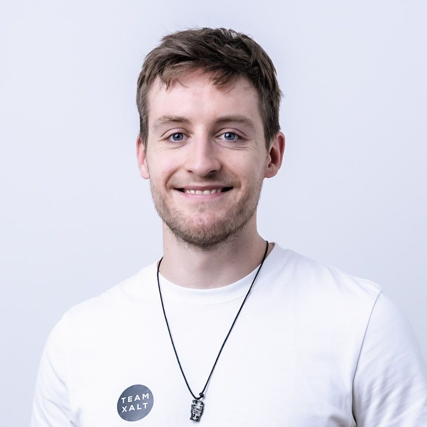 Tobias Koch lächelt in die Kamera und trägt ein weißes Shirt mit rundem XALT-Logo