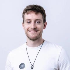 Tobias Koch lächelt in die Kamera und trägt ein weißes Shirt mit rundem XALT-Logo