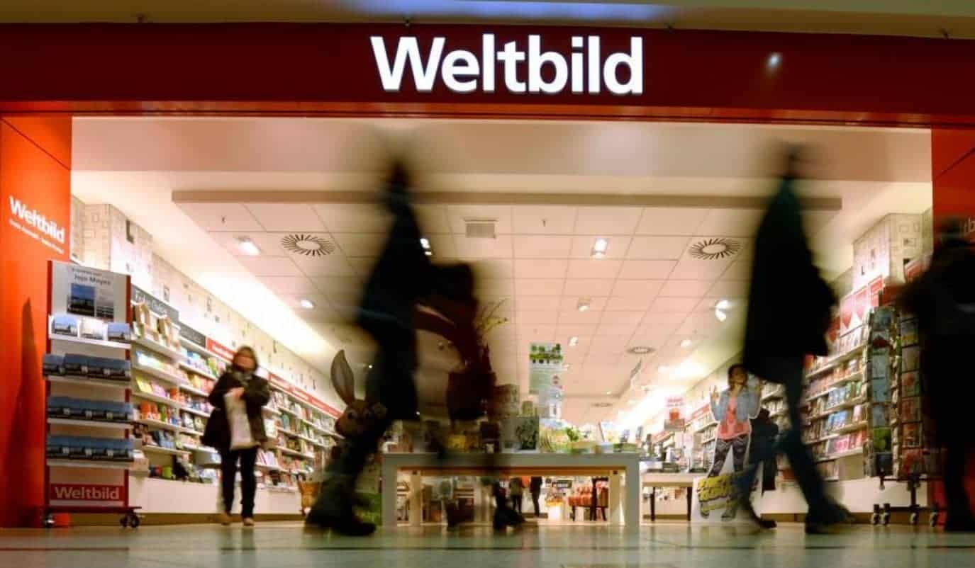 Eingang einer Weltbild-Filiale in einem Einkaufszentrum, Kundschaft läuft an gefüllten Bücher- und Zeitschriftenregalen vorbei