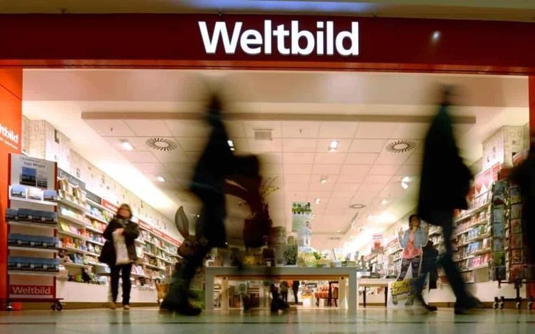 Eingang einer Weltbild-Filiale in einem Einkaufszentrum, Kundschaft läuft an gefüllten Bücher- und Zeitschriftenregalen vorbei