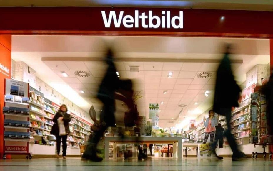 Entrance of a Weltbild store in a shopping centre, customers walking past shelves full of books and magazines
