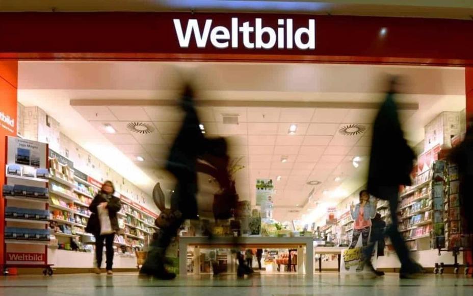 Eingang einer Weltbild-Filiale in einem Einkaufszentrum, Kundschaft läuft an gefüllten Bücher- und Zeitschriftenregalen vorbei