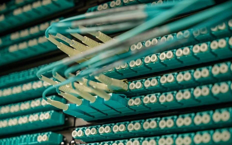 Nahaufnahme von Glasfaserkabeln, die in einem Rechenzentrum an ein Patchpanel angeschlossen sind