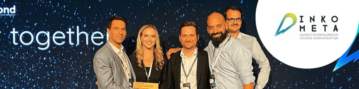 Fünf Personen mit Konferenz-Ausweisen stehen vor der blauen Sternenwand der INKOMETA-Bühne