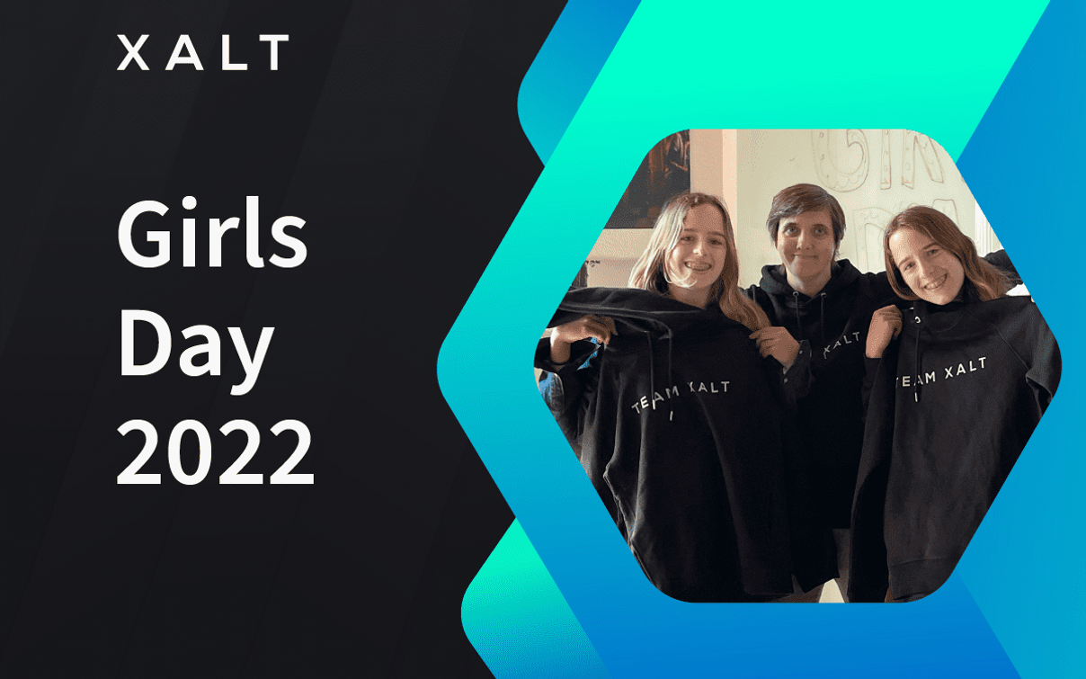 XALT Girls Day 2022 — drei junge Frauen halten schwarze XALT-Hoodies in einem Hexagon-Rahmen auf blauem Hintergrund.