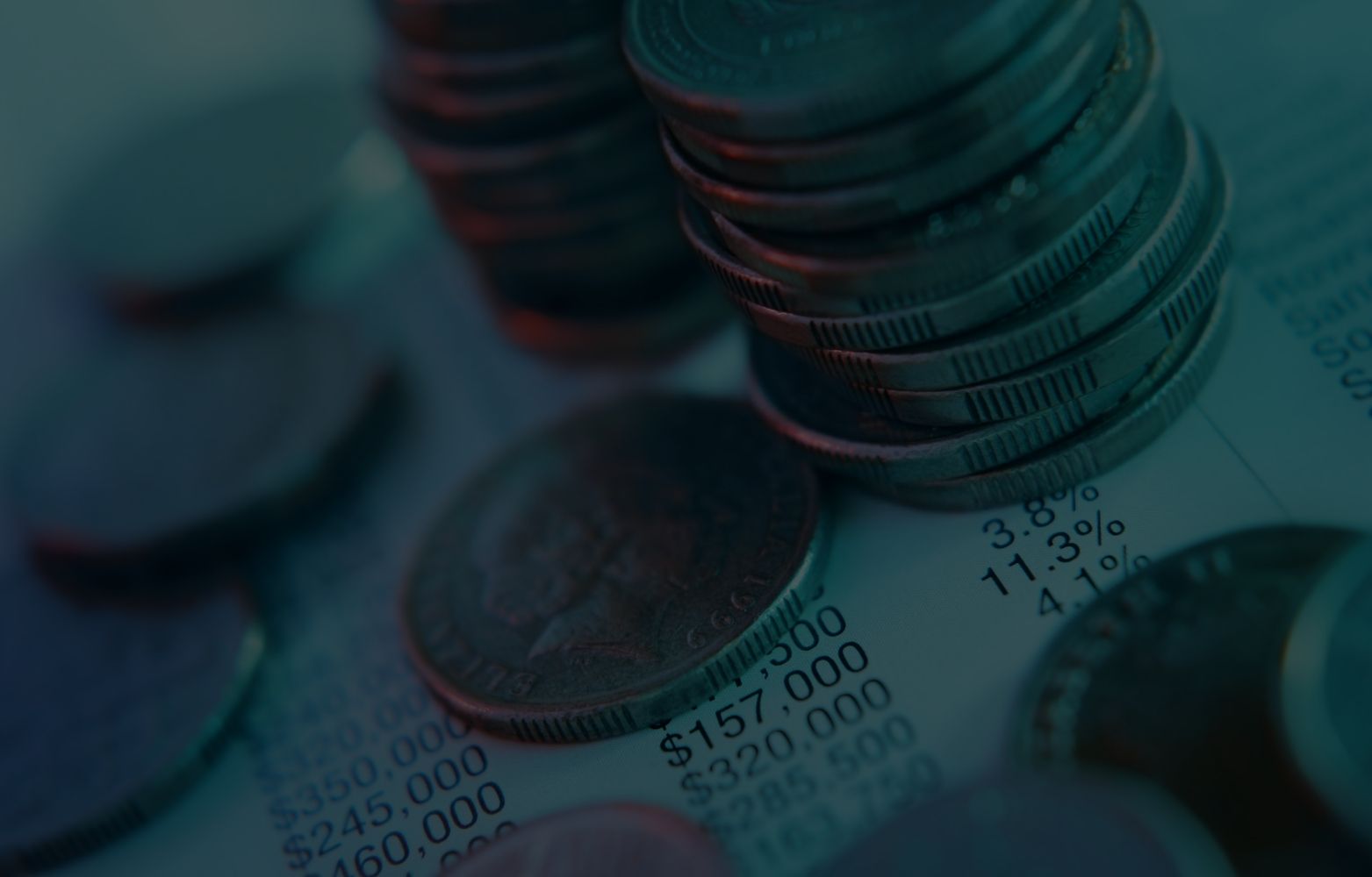 Münzstapel auf Finanzdokument mit Zahlen und Prozentangaben — Symbol für Kosten bei Cloud-Migration.