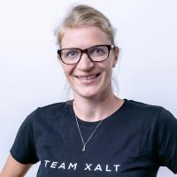 Helen Joas lächelt mit Brille in die Kamera und trägt ein schwarzes TEAM-XALT-Shirt