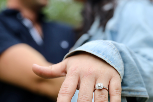 Couple holding hand out with engagement ring on finger