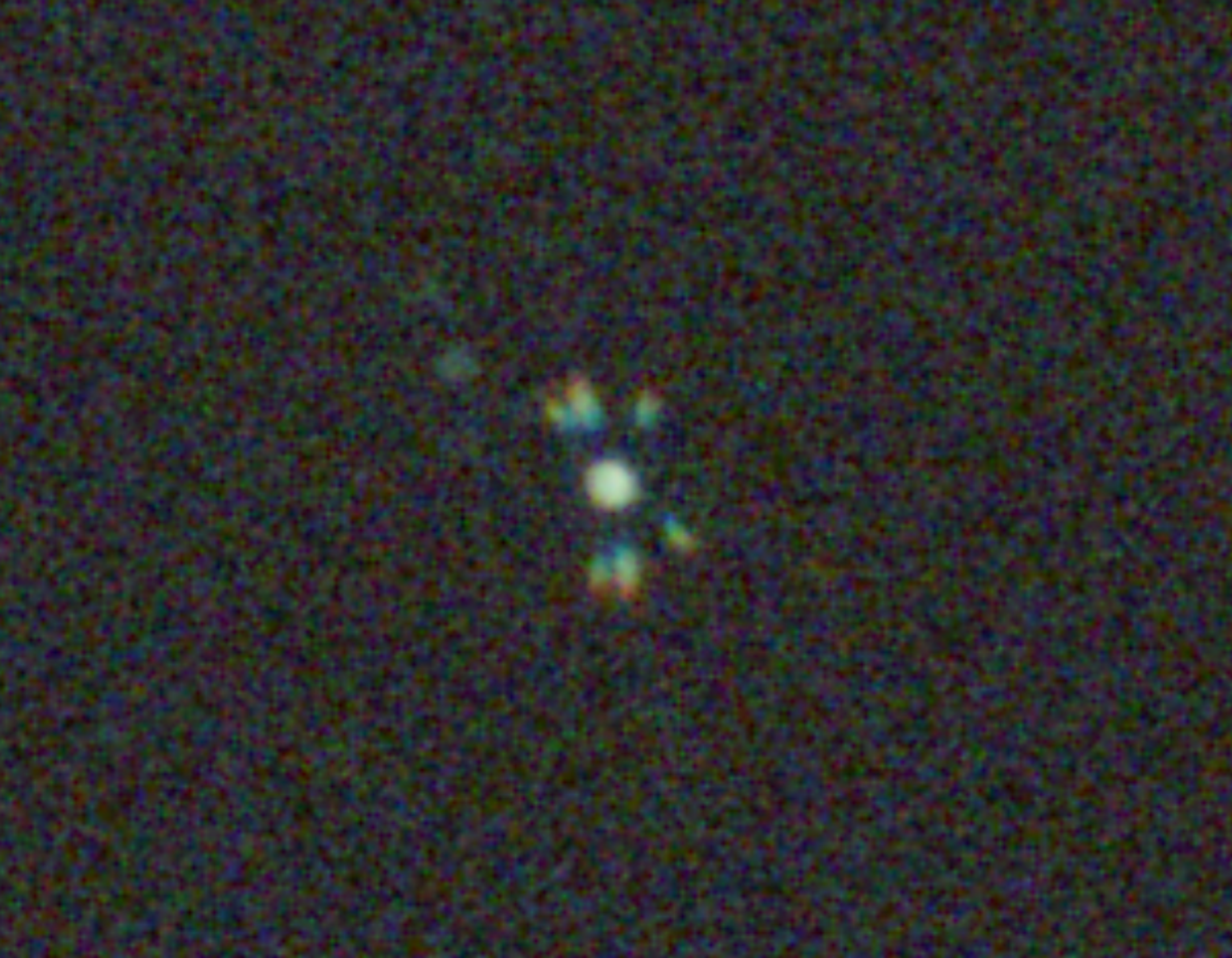 A star's Bahtinov diffraction spikes on a live-view screen, spread and uneven — out of focus