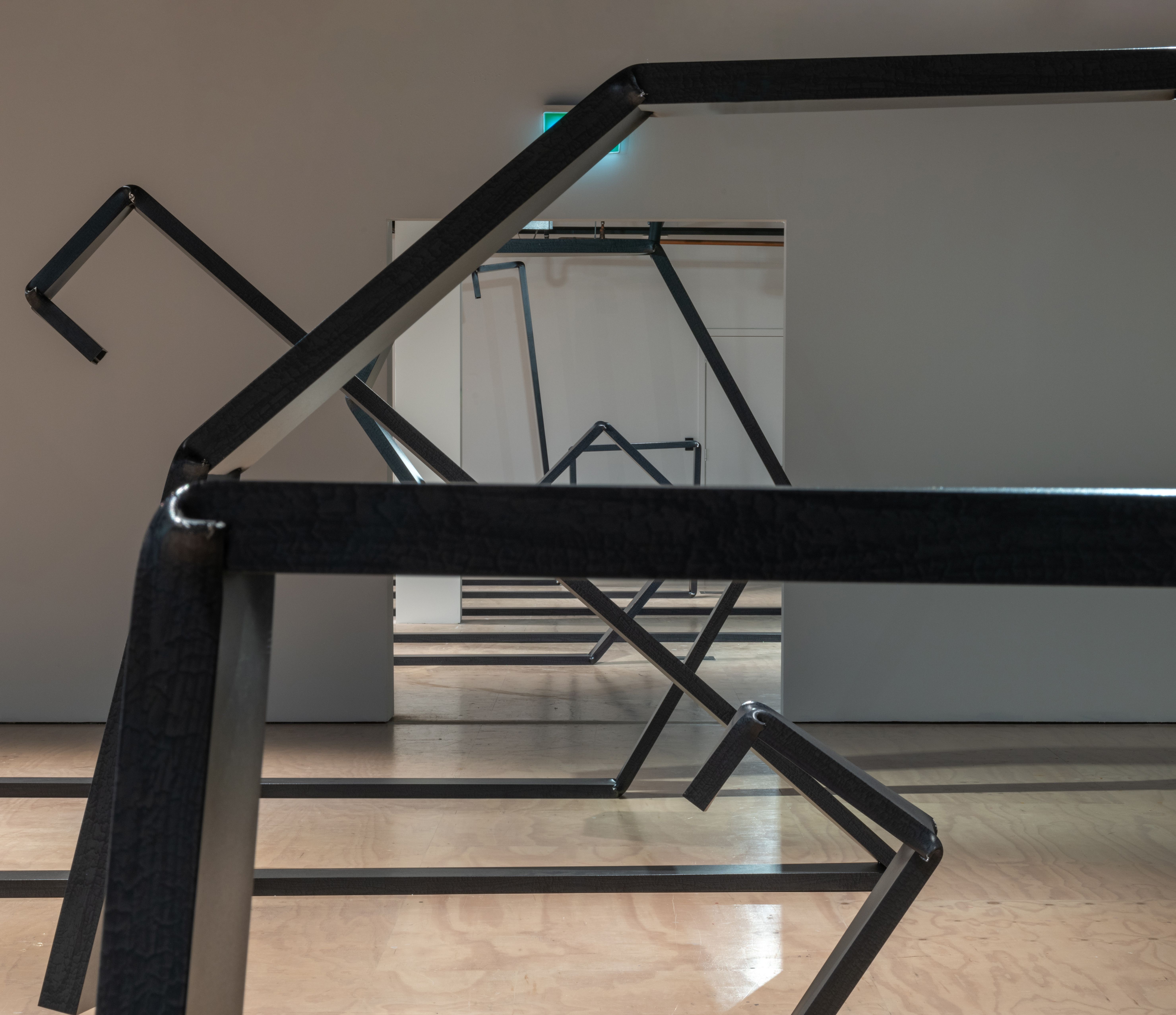 Black steel bars curved into koru shapes 