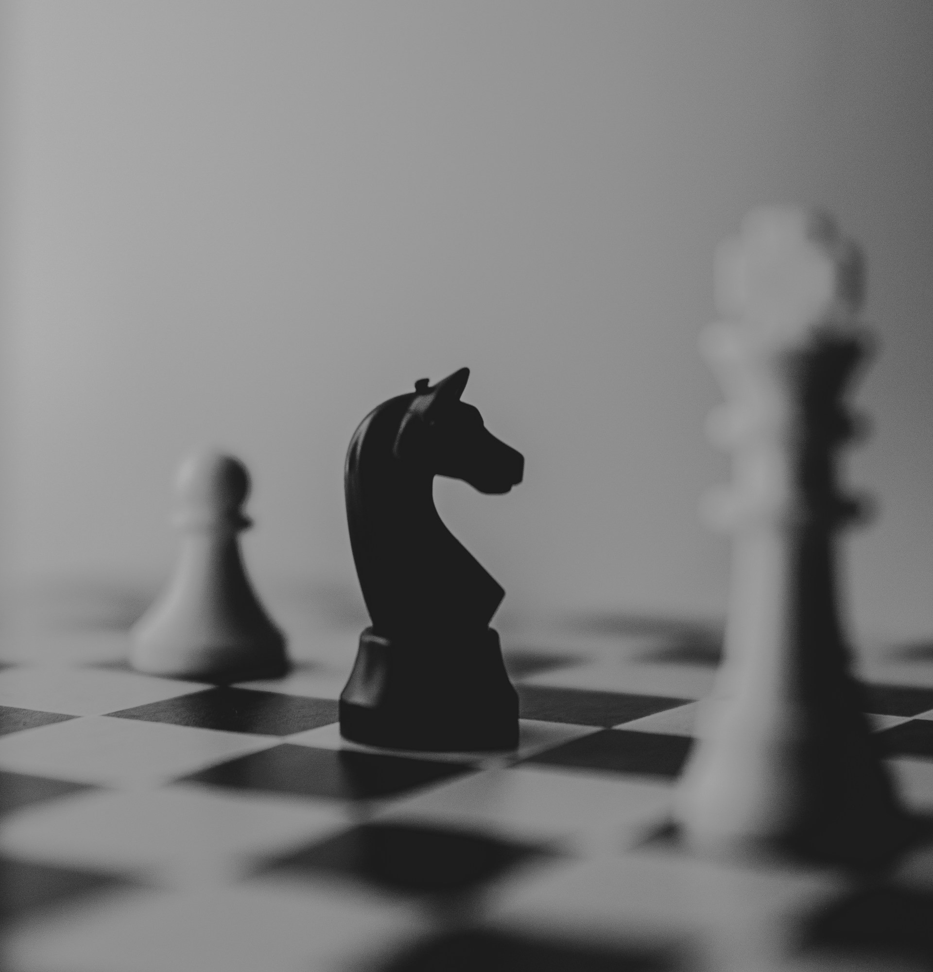 Chess board with white pawn, queen and black knight