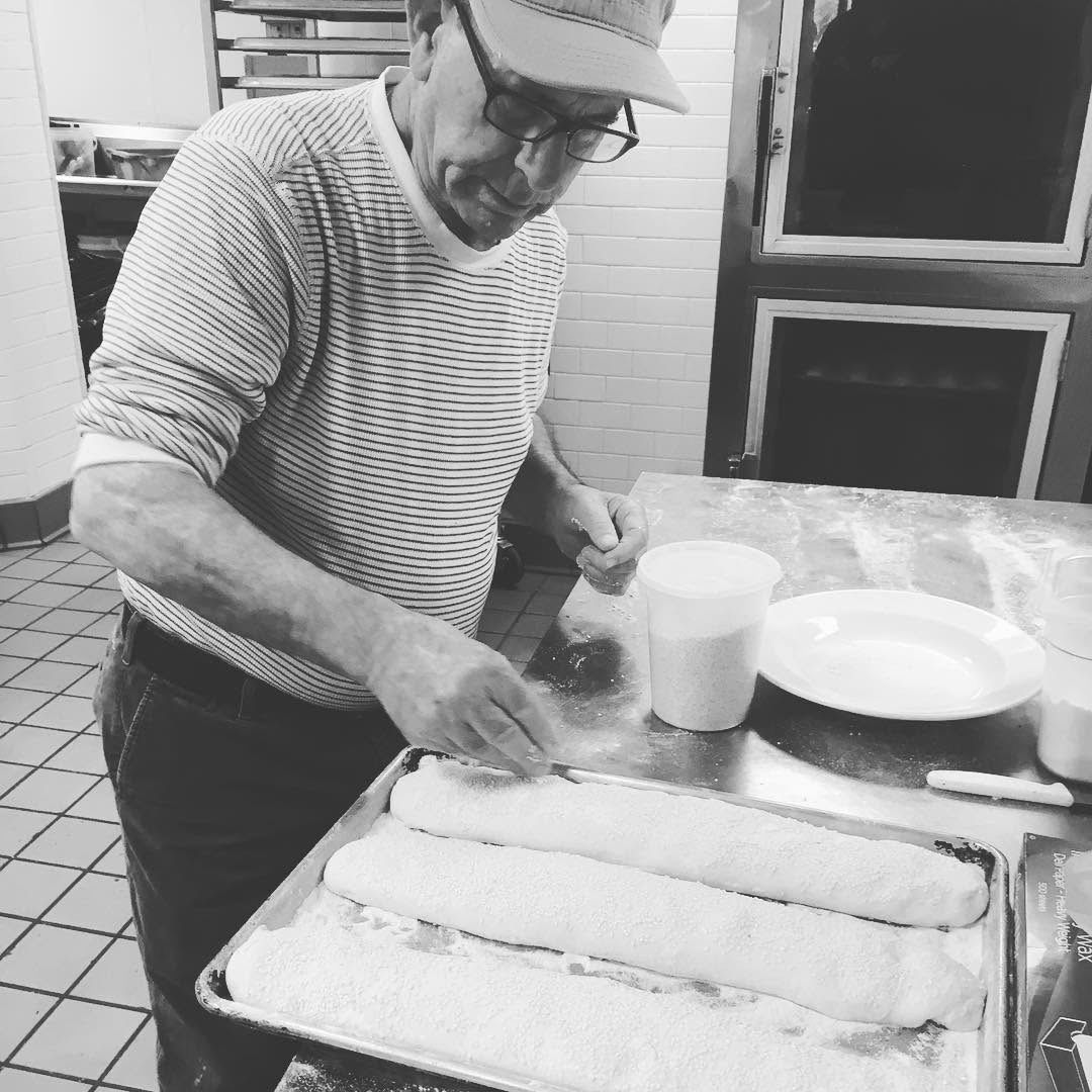 A baker shaping loaves in a supplied black-and-white photograph