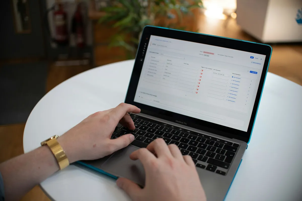 Hands typing on a laptop with spreadsheet data on screen — the actual work an AI SDR replaces