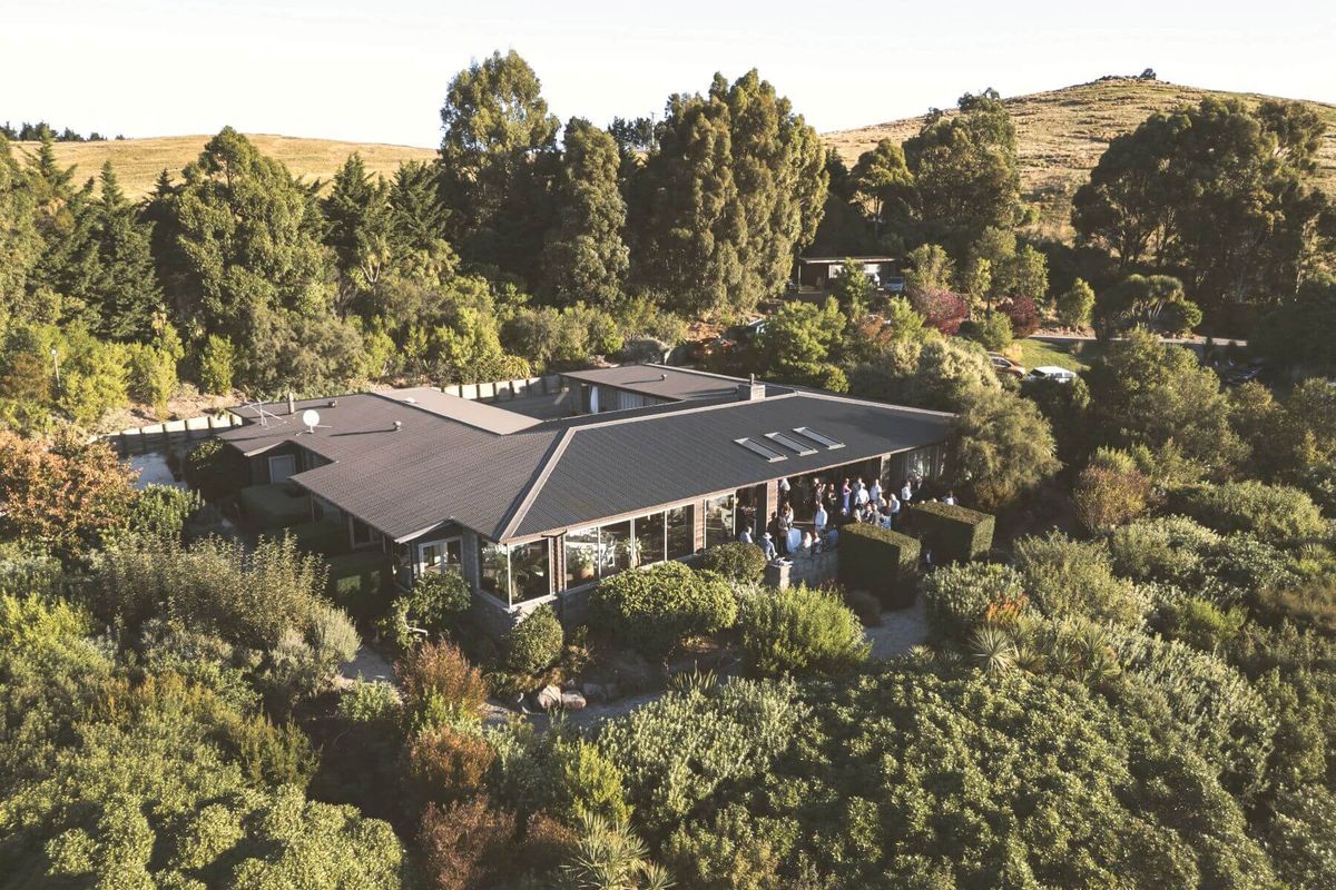 Aerial view of Waipuna Estate's venue building set among hills and greenery
