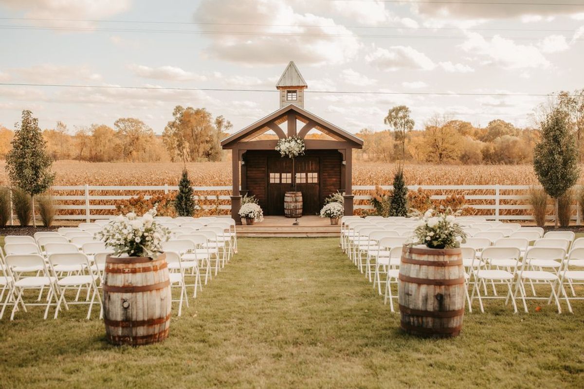 Outdoor ceremony space at Barn 1888 with a wooden chapel structure and cornfield backdrop