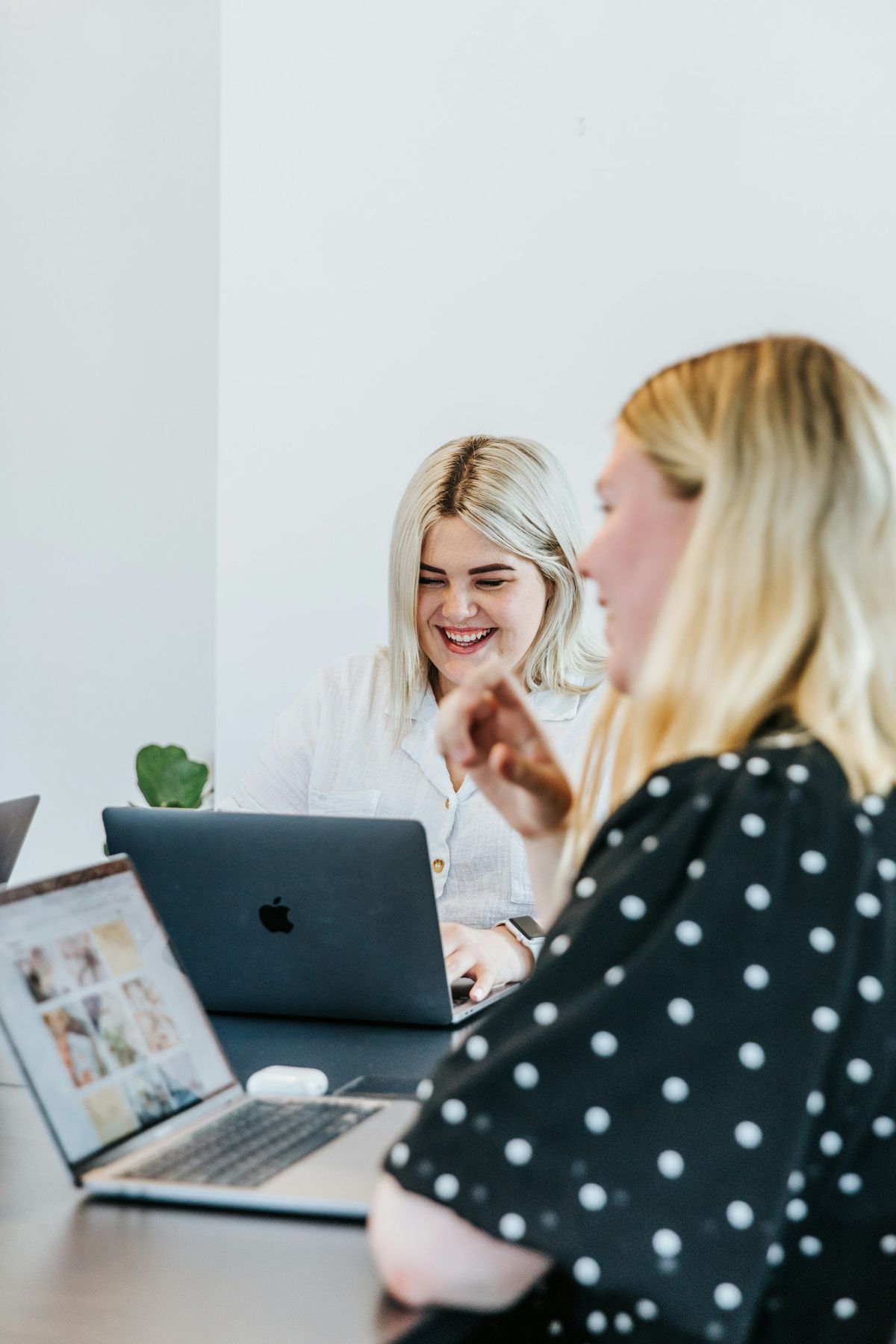 Two women laughing as they manage social media