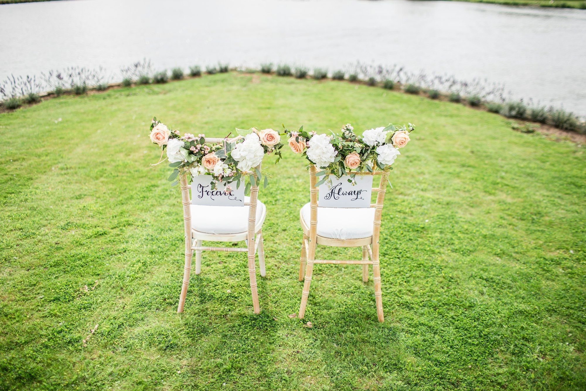 Two wedding chairs by a lake