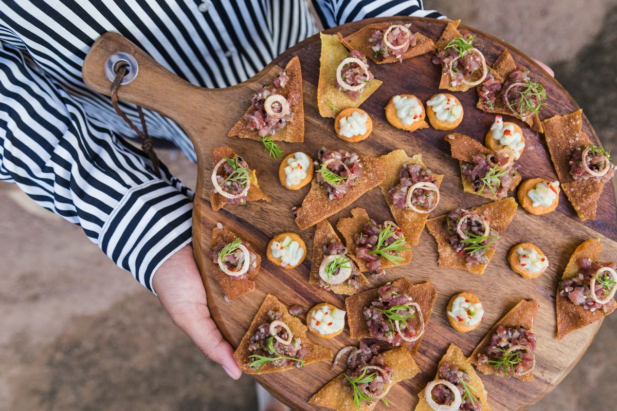 A wooden serving board of canapés