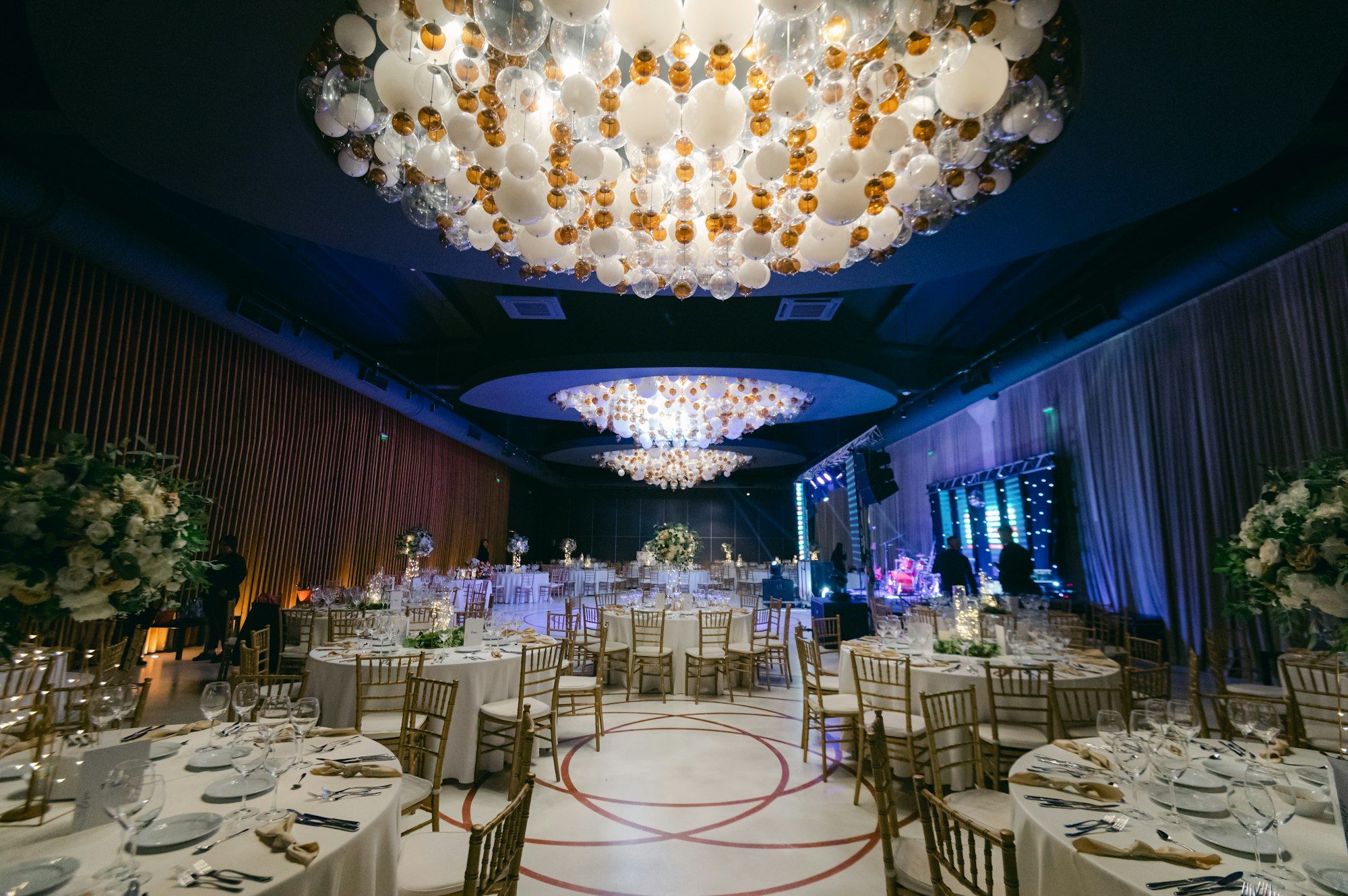 Elegant ballroom set up for a wedding reception with round tables and chandeliers