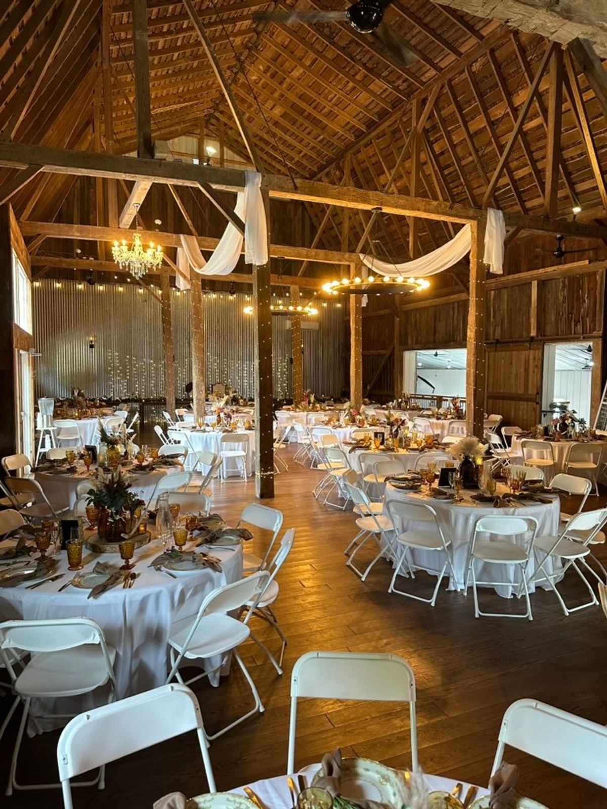 Rustic barn reception at Barn 1888 set with round tables and fairy lights