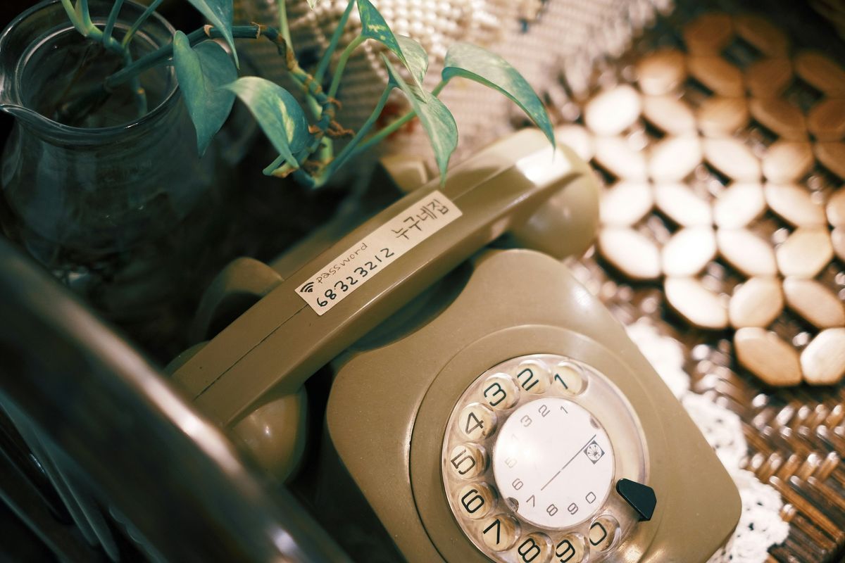 An old-fashioned telephone on a table next to a plate of biscuits