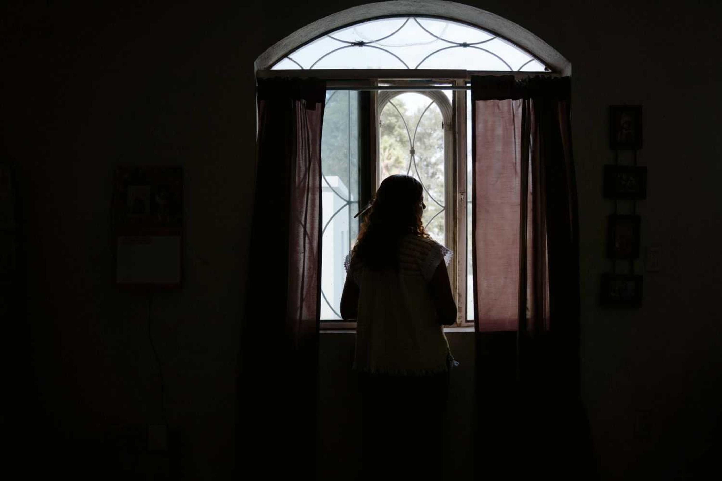 Silhouette of Beatriz looking out the window in Mexico