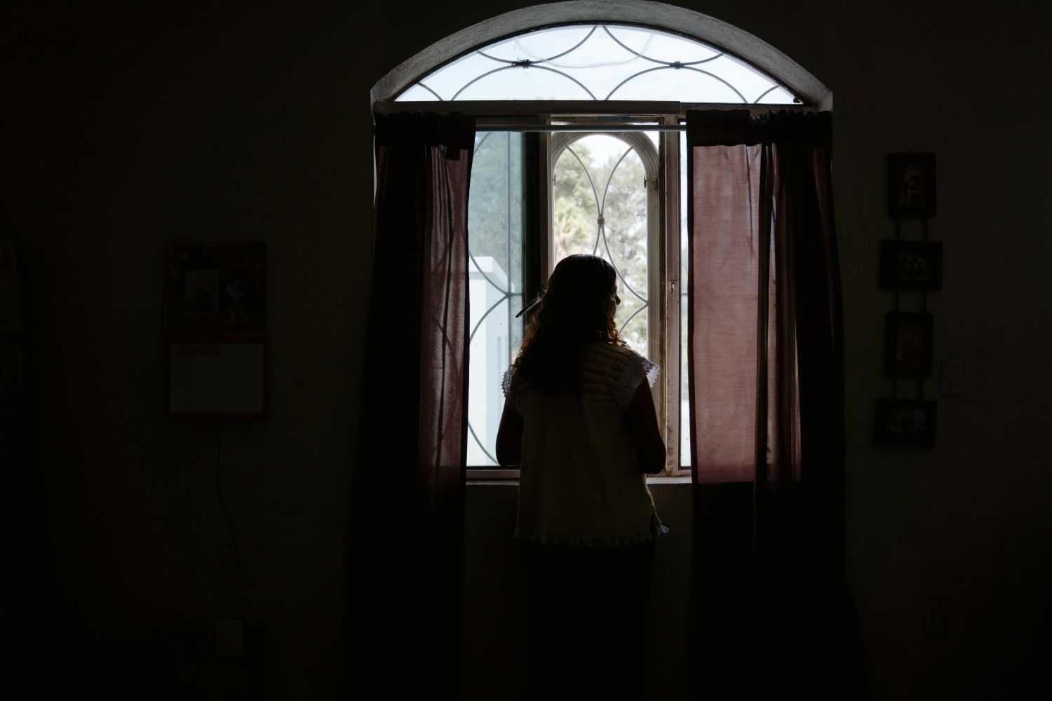 Silhouette of Beatriz looking out the window in Mexico