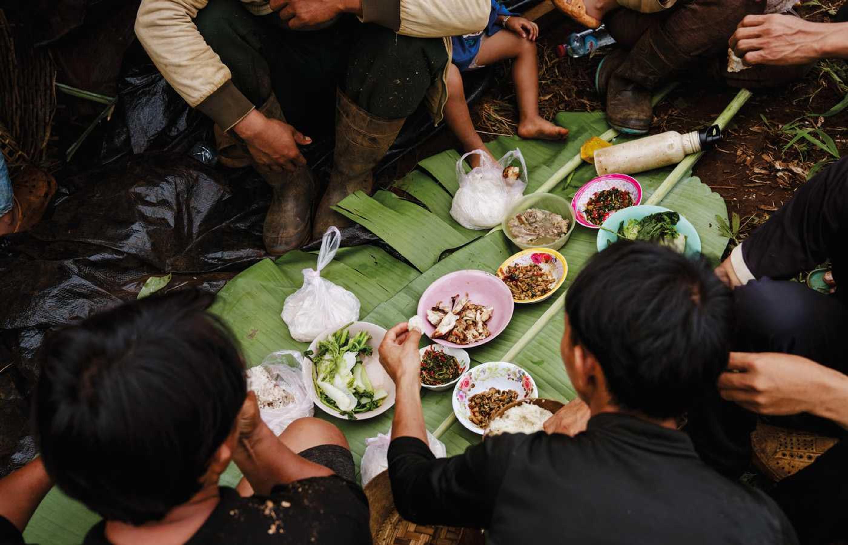 En husförsamling i Laos har samlats för att äta lunch tillsammans.