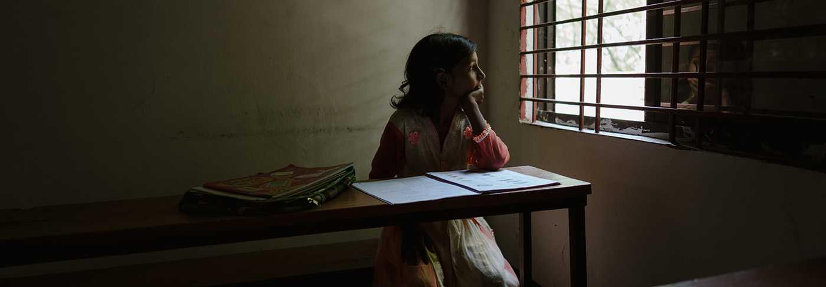 A girl in Bangladesh looking out the window at school