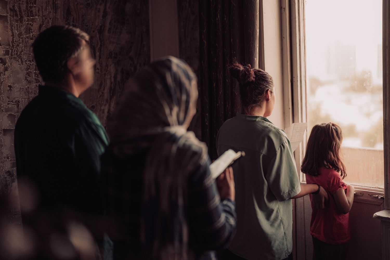 Ariana and her family standing in front of a window