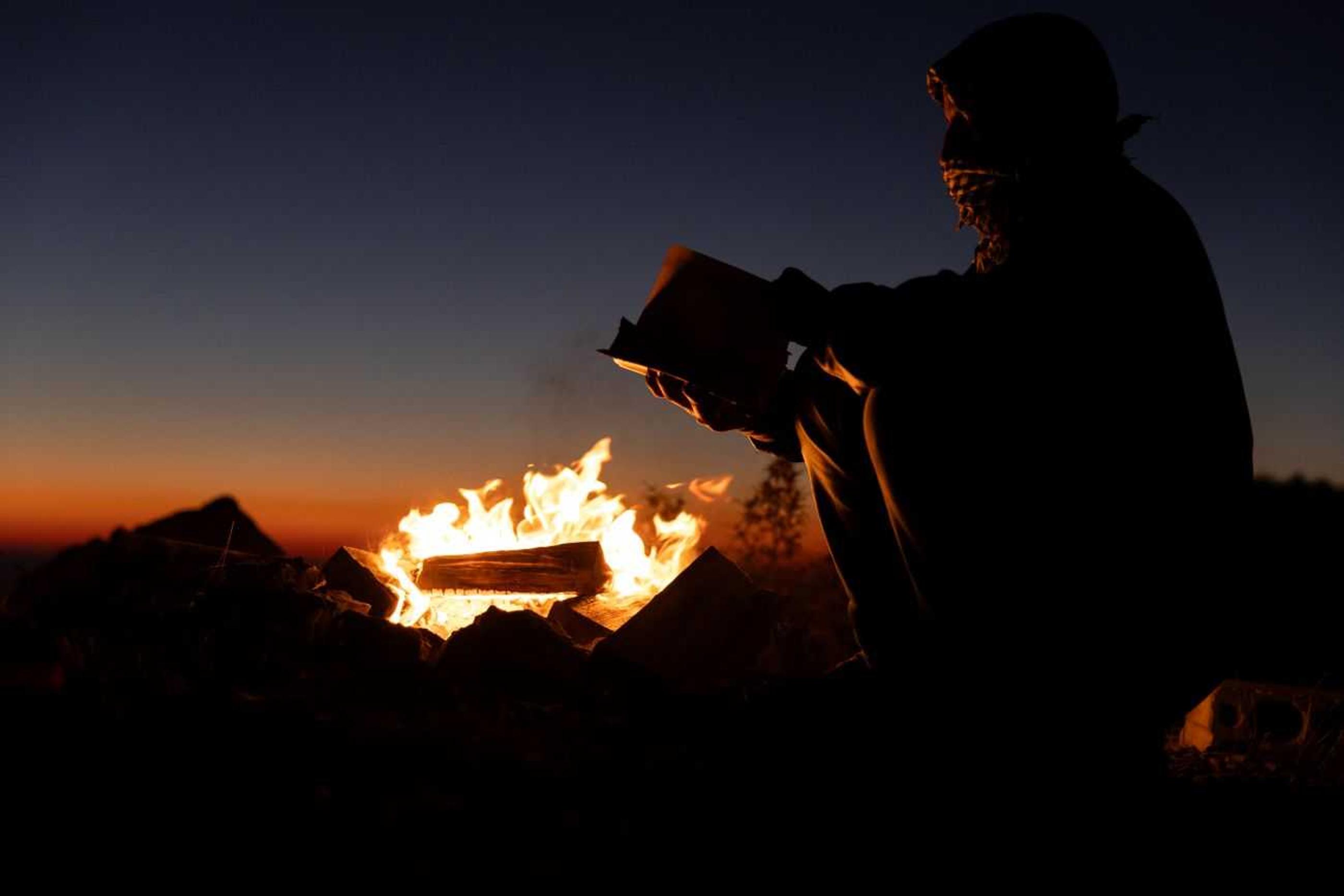 Zaid reading his Bible by the fire