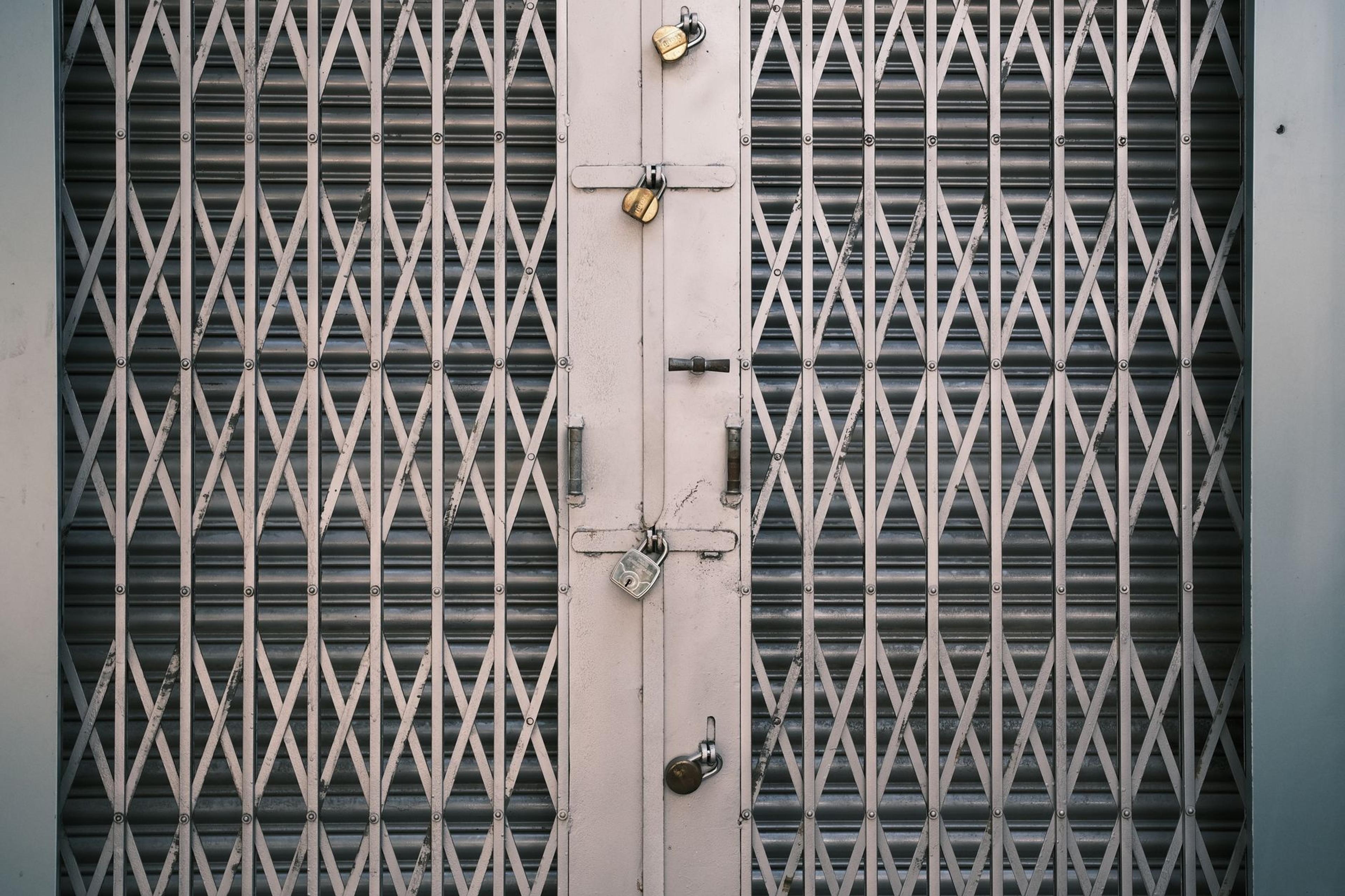 A secure metal gate with multiple locks in Bengaluru, India. Symbolizes security and protection.