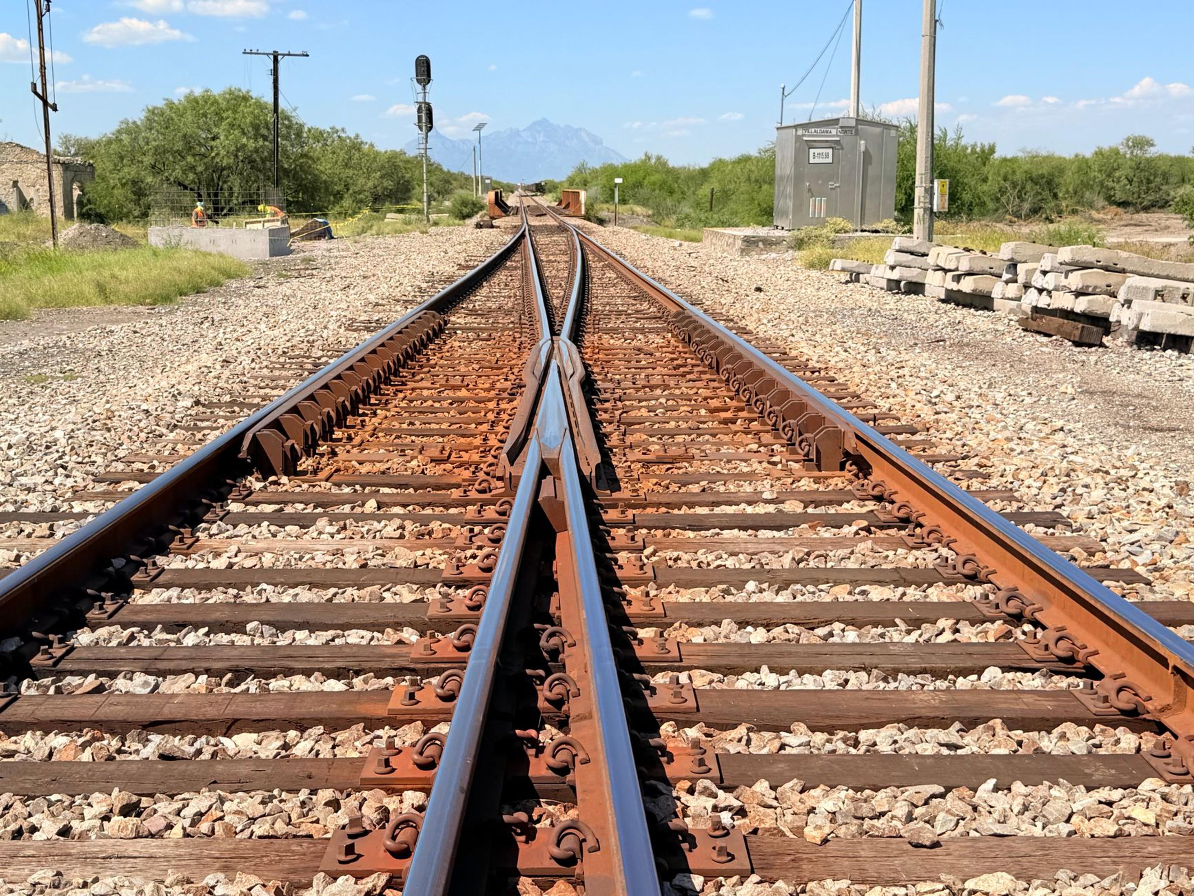 A sunny view of rustic railway tracks disappearing into the distant mountains. Perfect for travel themes.