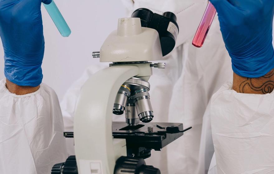 scientist holding two test tubes of different colours