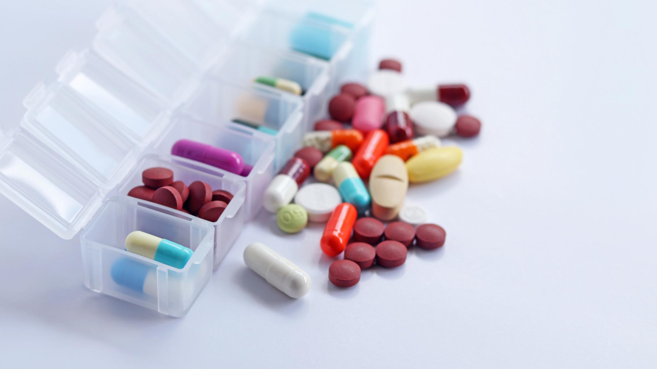 Pills in and around pill organizer container