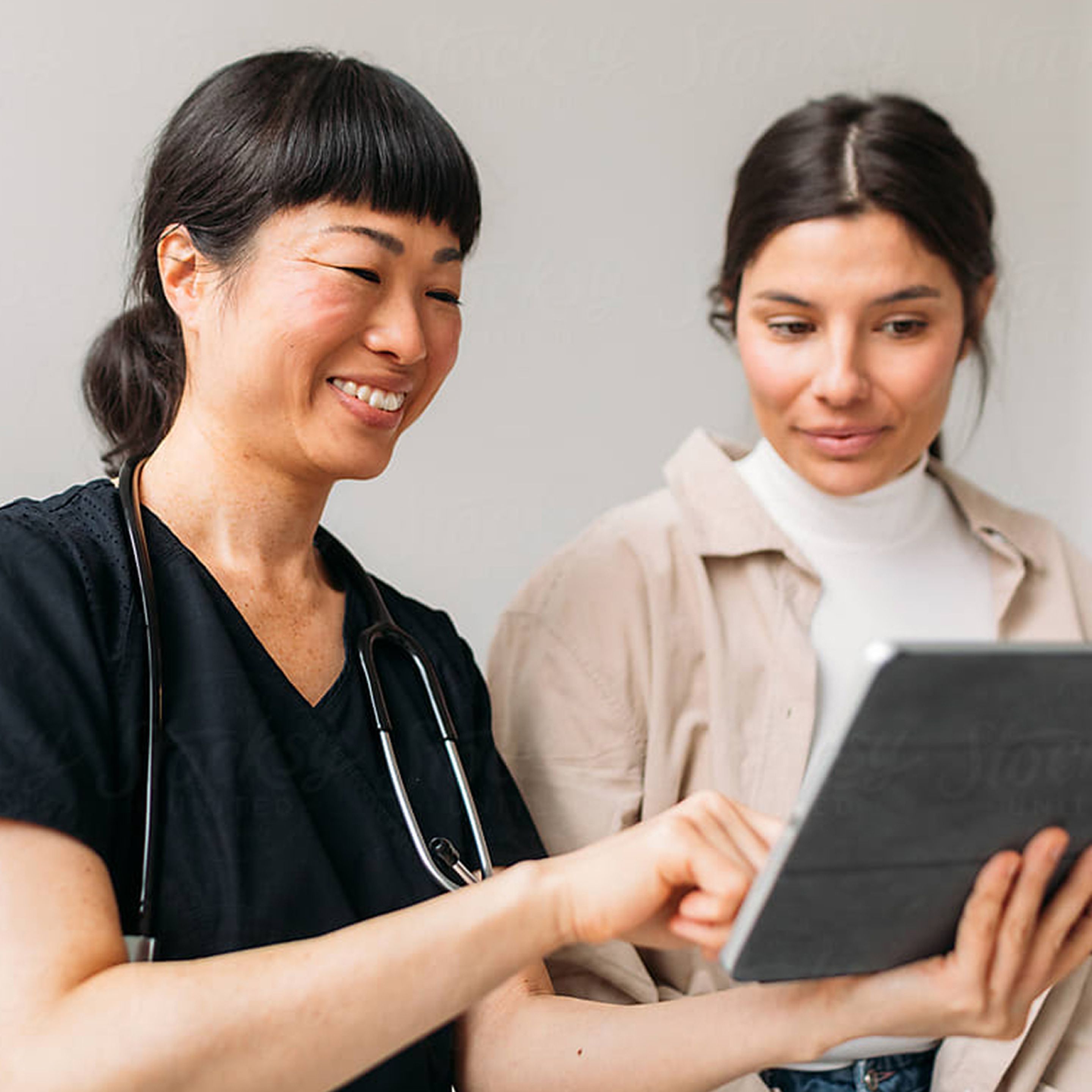 A health guide pointing out something to a patient on a tablet