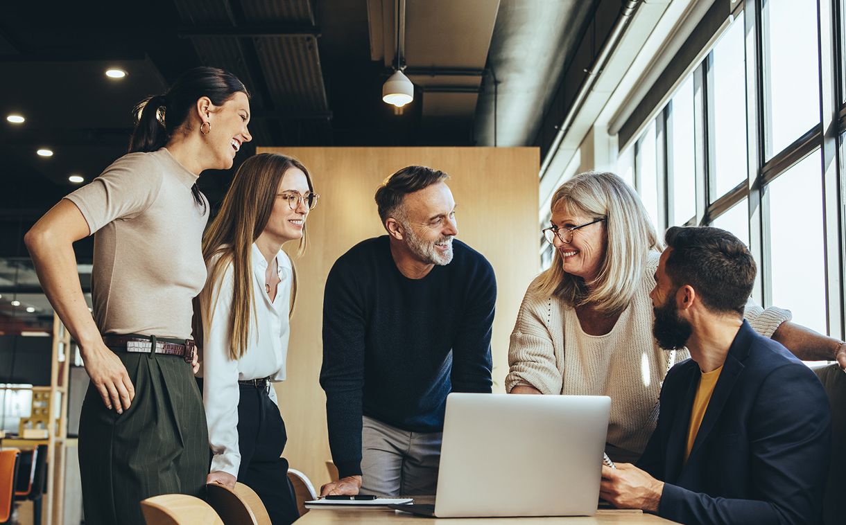 Coworkers having an informal meeting around a laptop