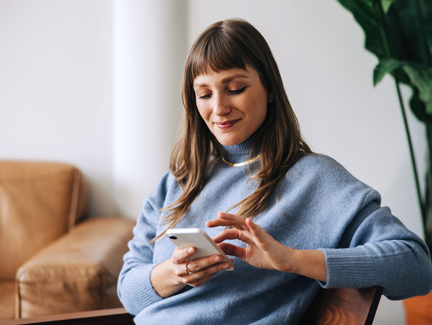 woman sitting looking at smart phone