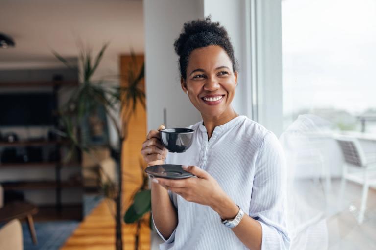 Woman over 40 sipping coffee at home