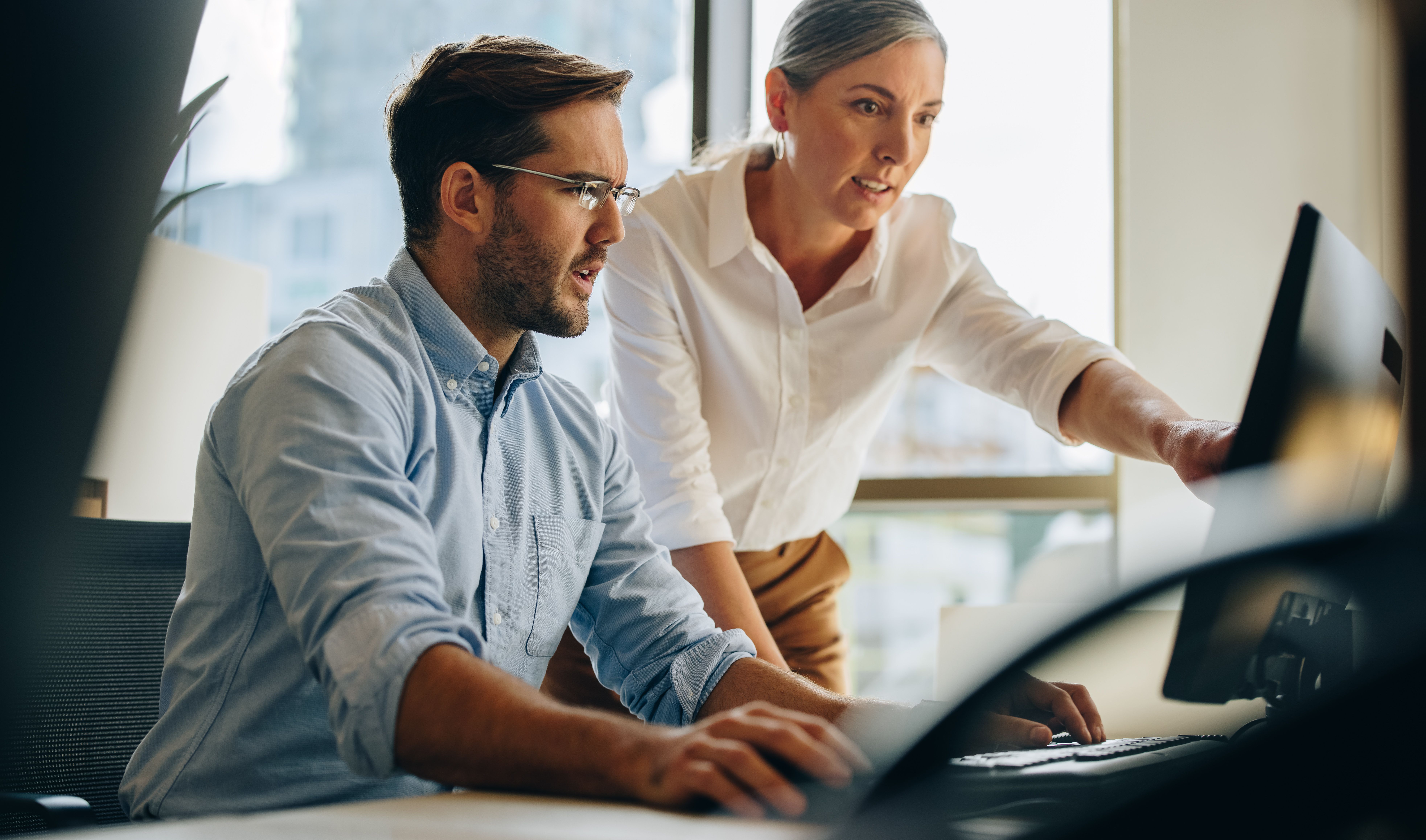 Man and woman coworkers looking at computer