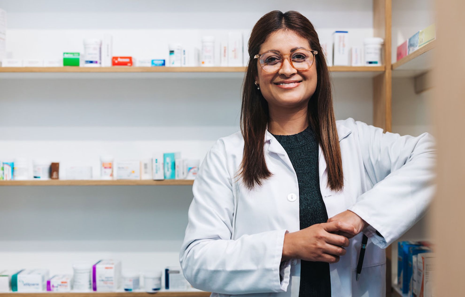 Female pharmacist smiling in pharmacy