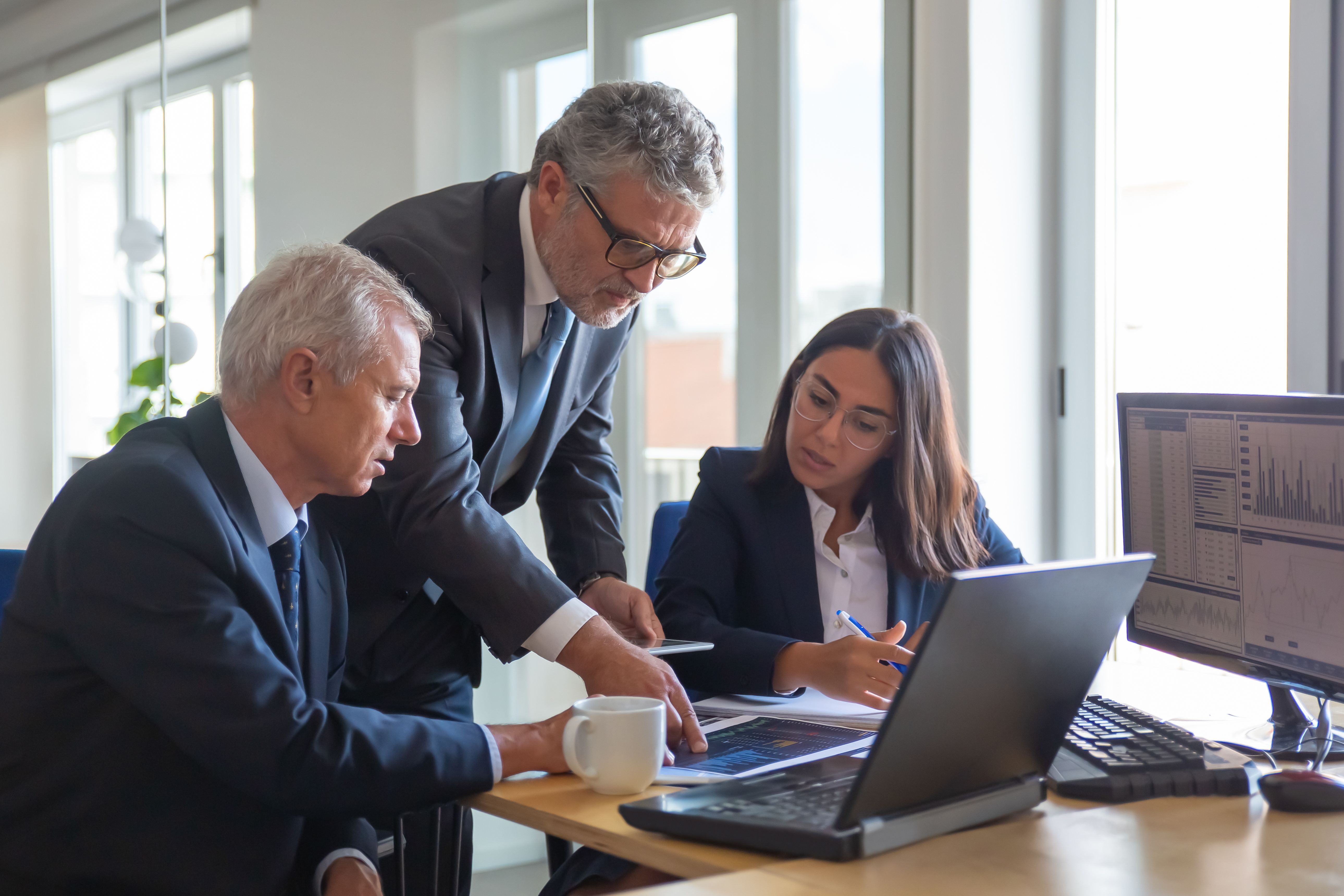 three coworkers looking at computer screen