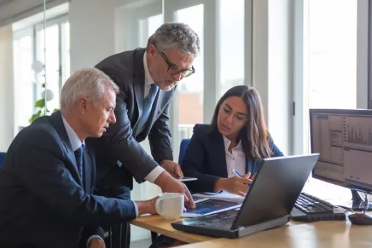 three coworkers looking at computer screen
