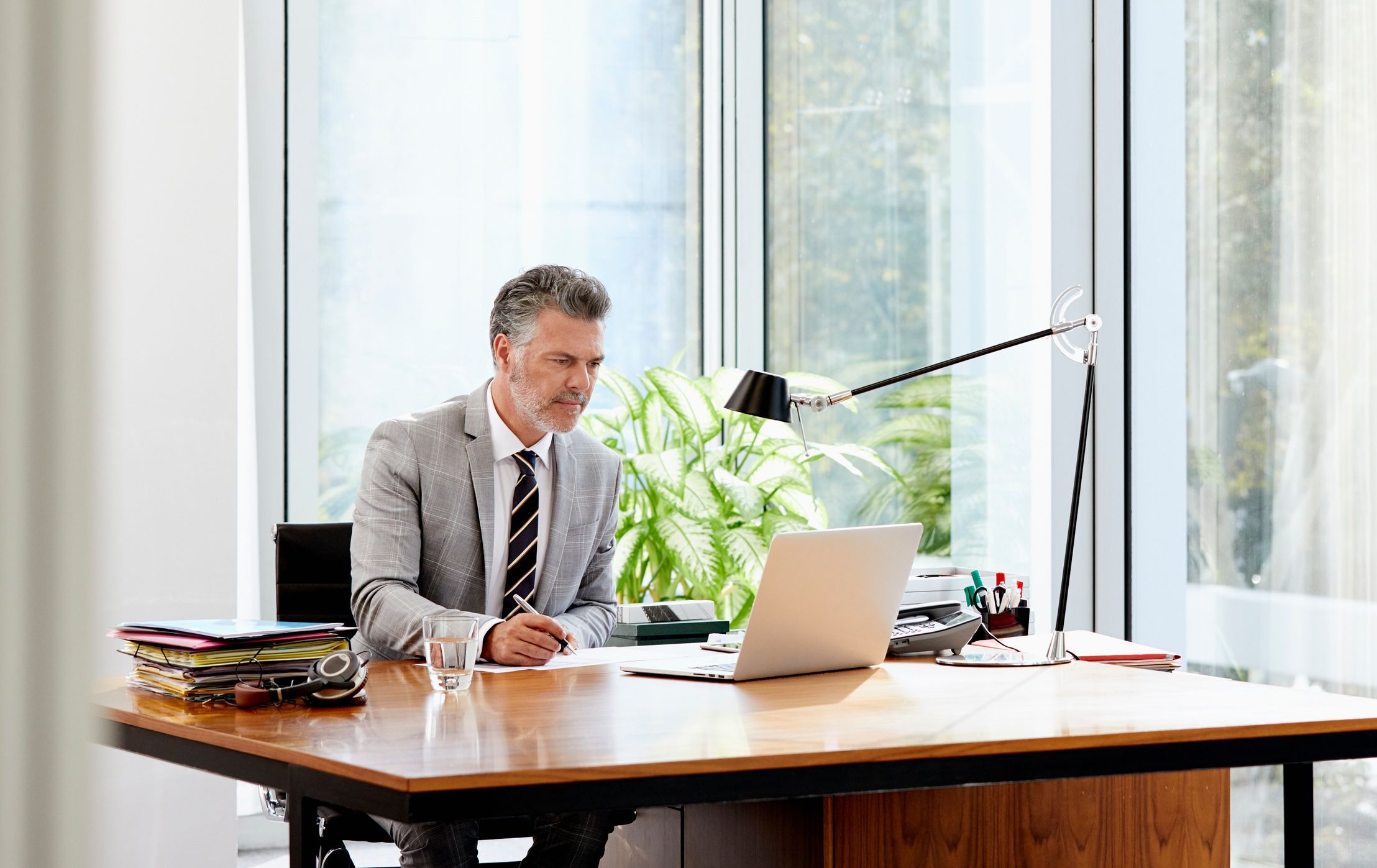 Professionally dressed man sitting at desk working at computer