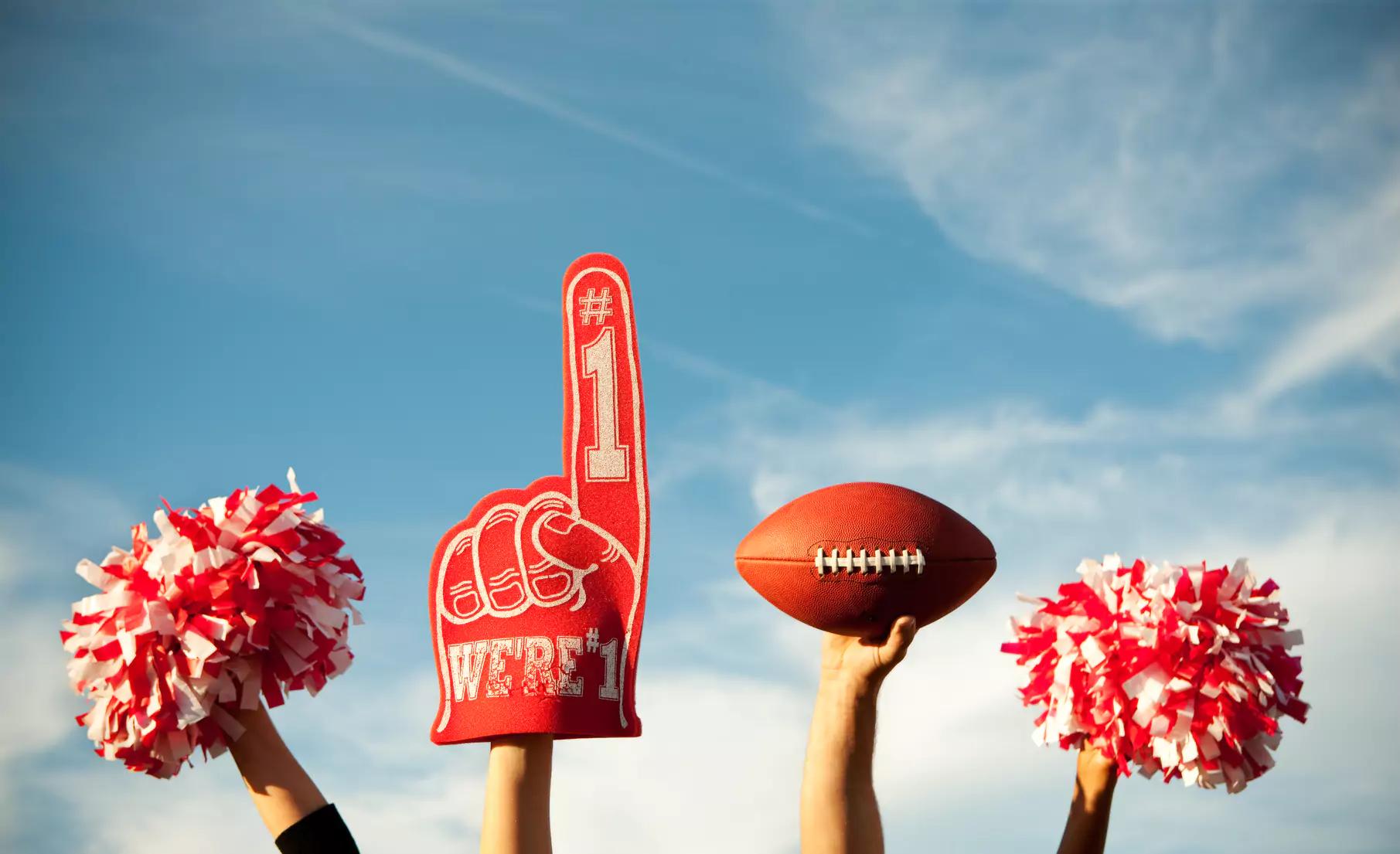 Red foam finger, football, and pom poms