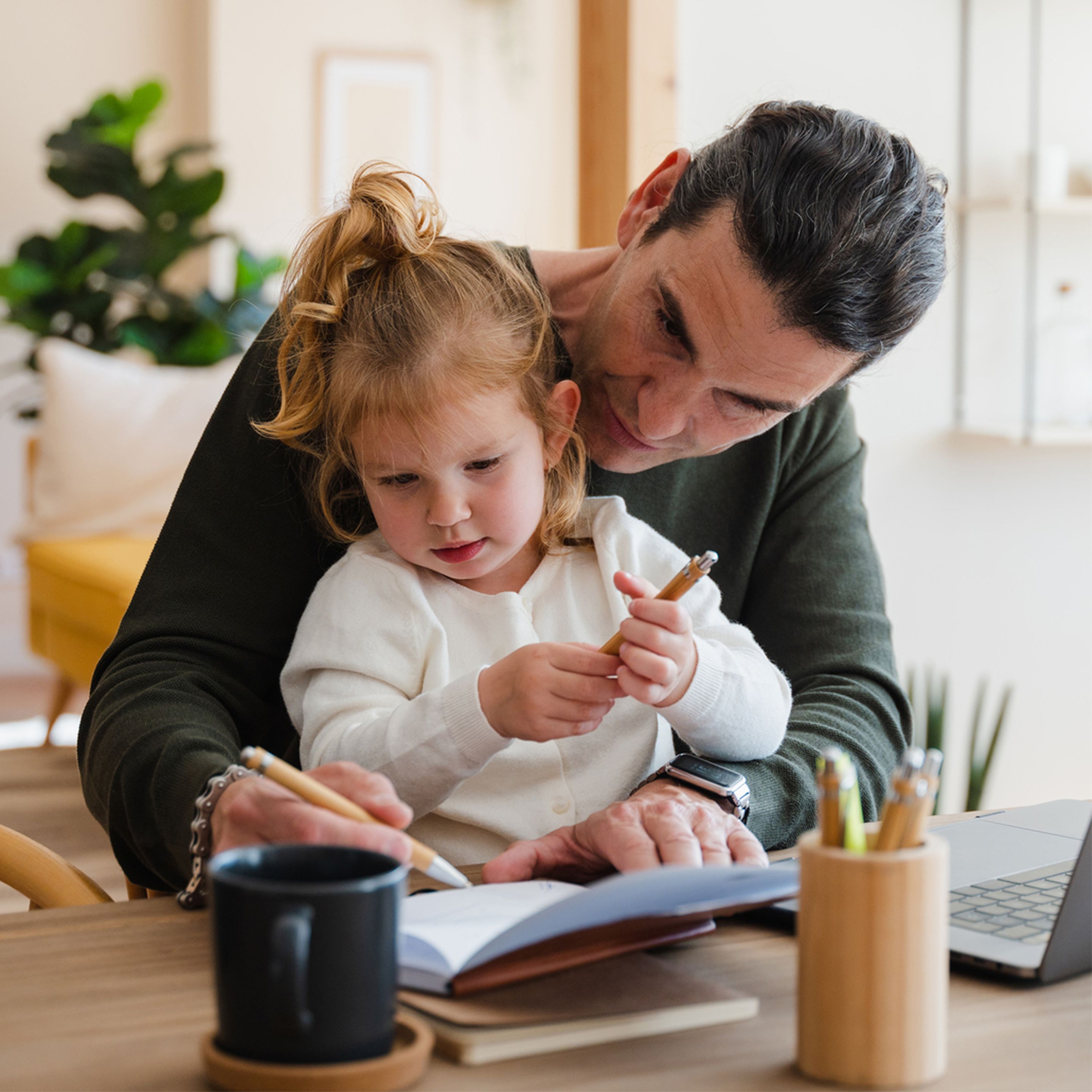 Man with his child drawing in notebook