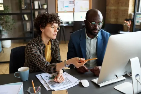 Business People Discussing Presentation on Computer.