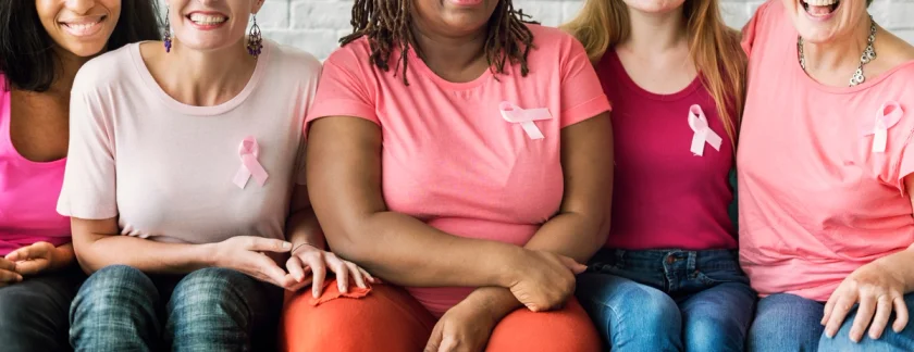 Women in pink wearing breast cancer support ribbons