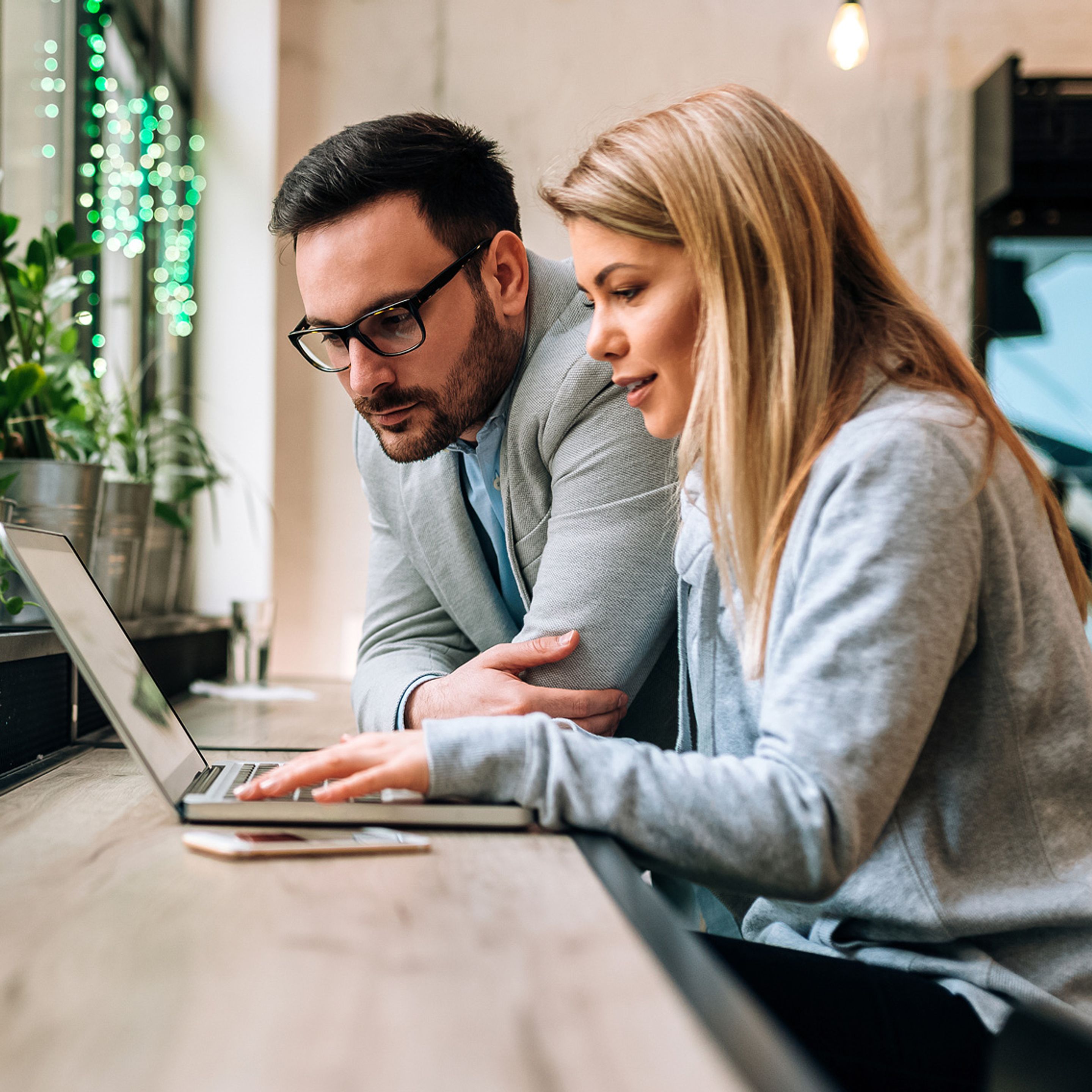 Two coworkers looking at laptop