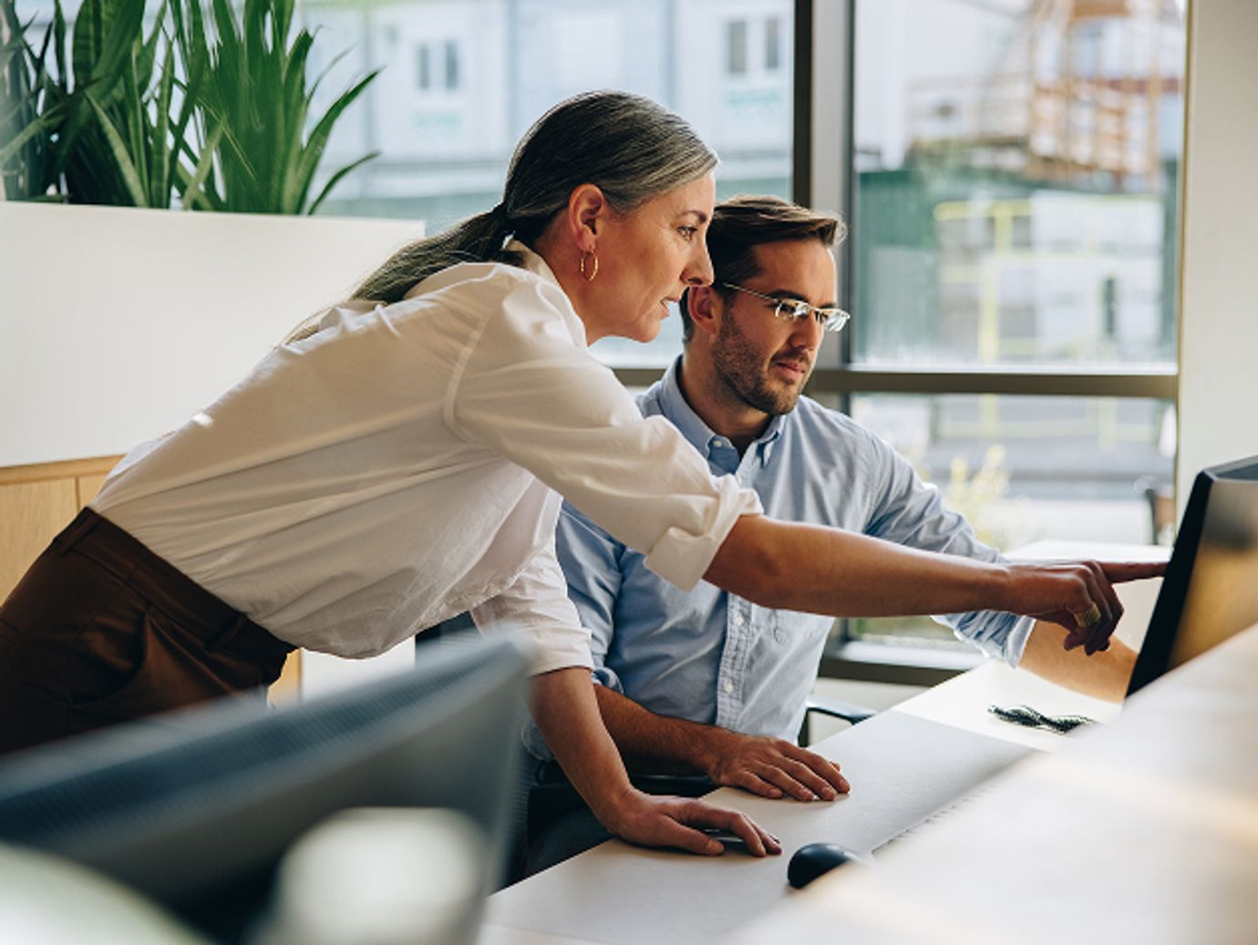 Female and male coworkers looking at computer screen